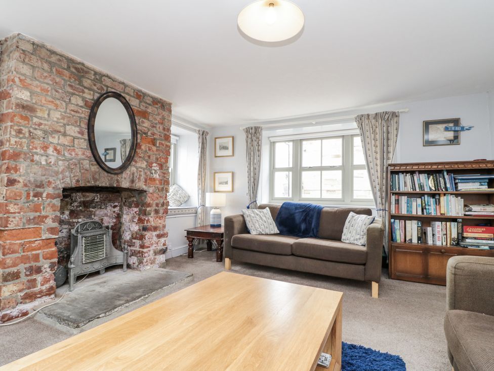 A living room with a fireplace and bookshelf at Shelstone in Whitby