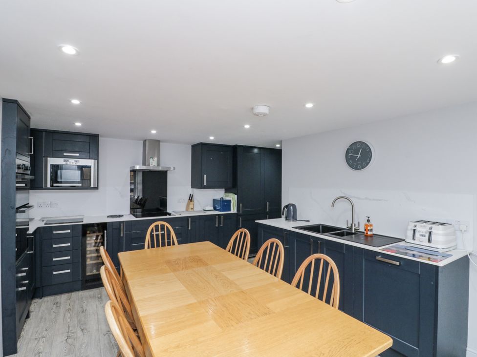 A kitchen with cabinets and dining table at Shelstone in Whitby