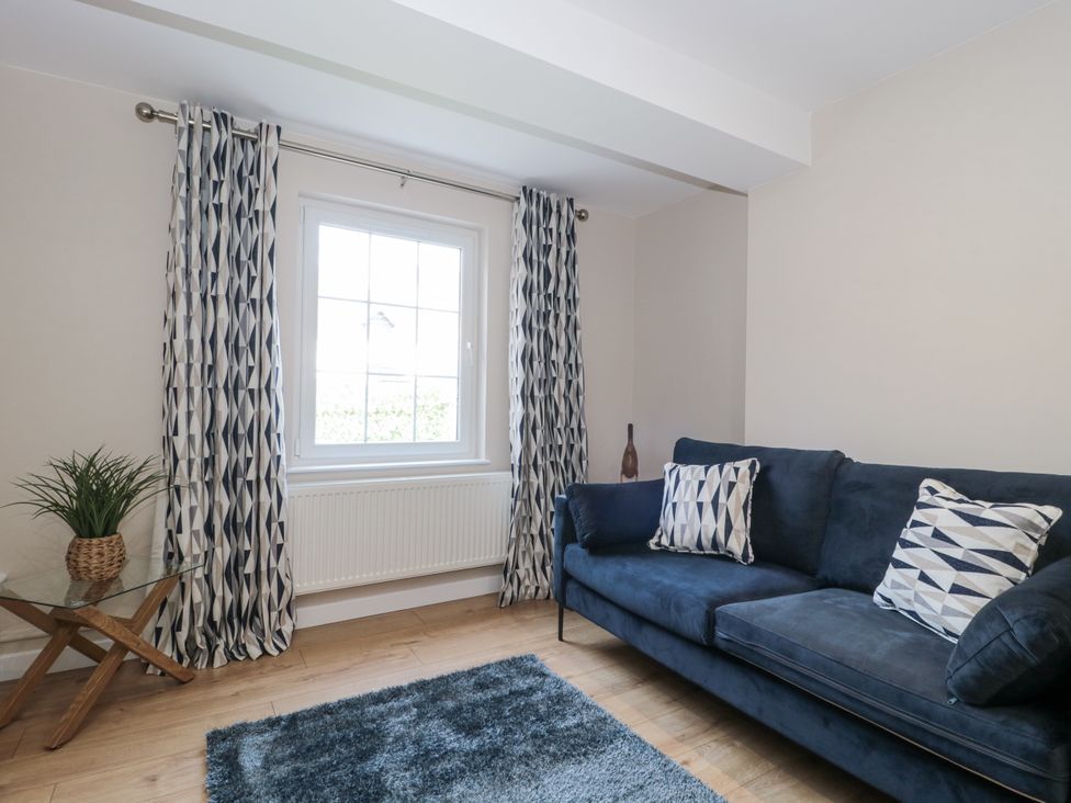 A living room with a blue sofa and curtains at Royal Terrace Sunset in Weymouth
