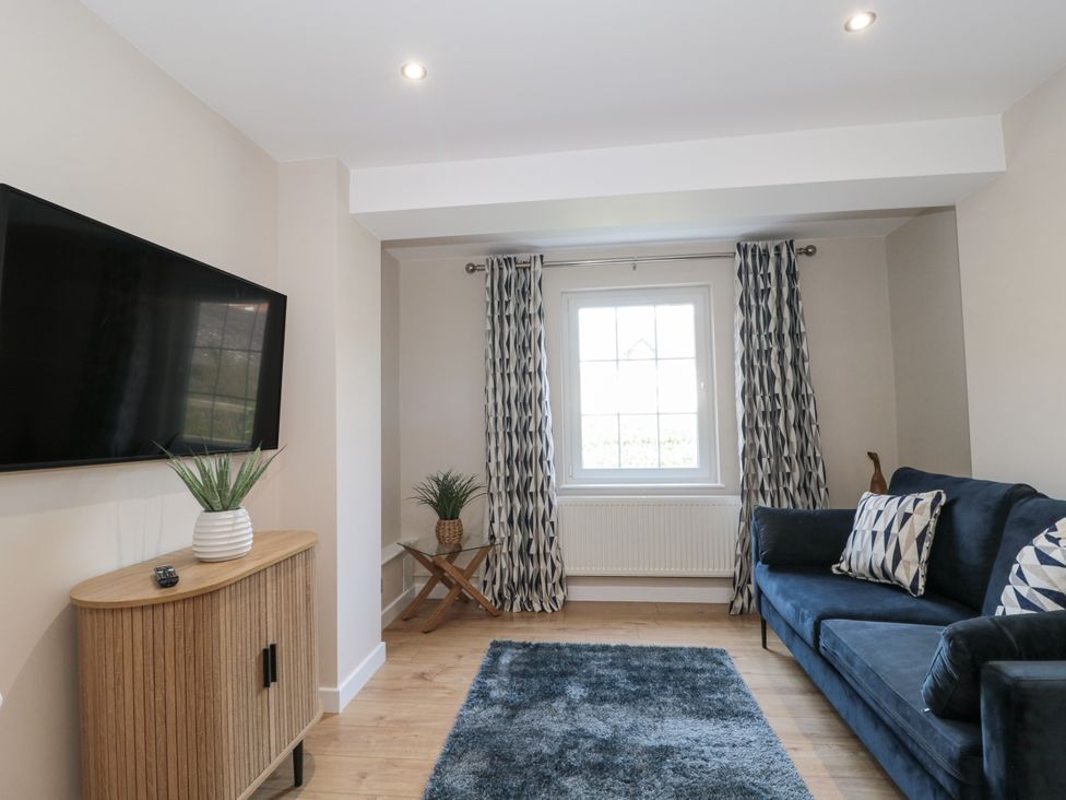 A living room with a television and sofa at Royal Terrace Sunset in Weymouth