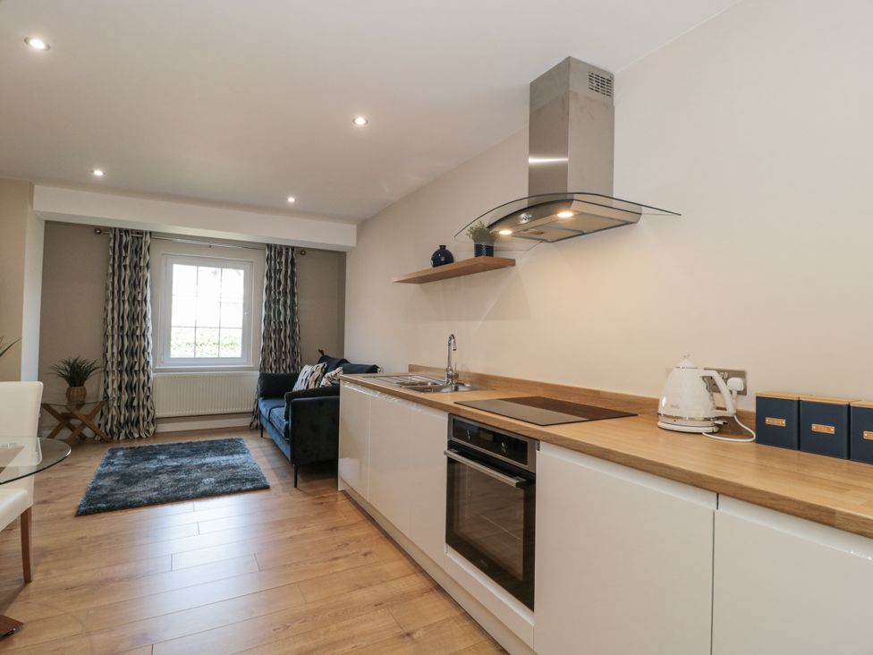 A kitchen with a sink, stove, oven and seating area at Royal Terrace Sunset in Weymouth