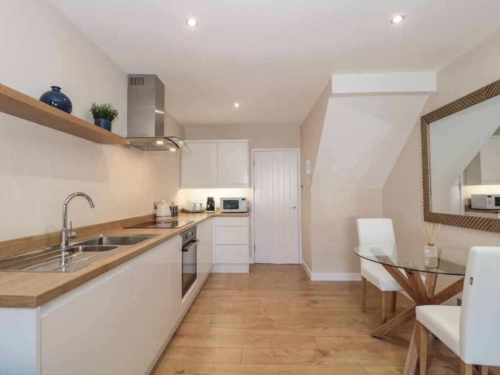 A kitchen with appliances and dining area at Royal Terrace Sunset in Weymouth