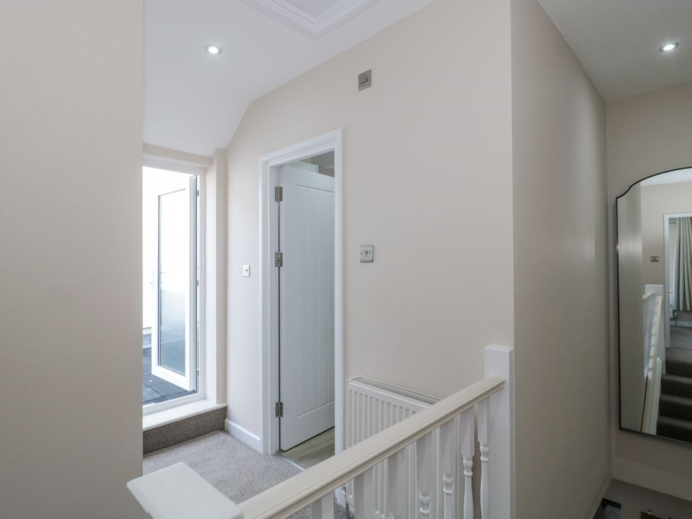 A hallway with a staircase and doors at Royal Terrace Sunset in Weymouth