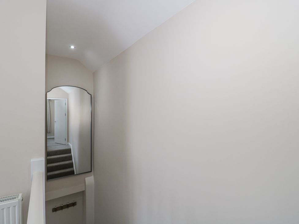 A hallway with a mirror and light fixtures at Royal Terrace Sunset in Weymouth