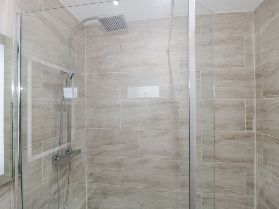 A shower area with tiles and glass panel at Royal Terrace Sunset in Weymouth