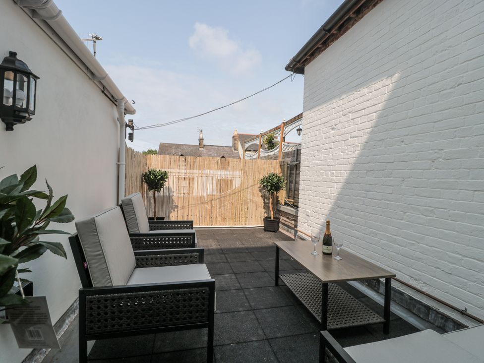 An outdoor area with seating and a table at Royal Terrace Sunset in Weymouth