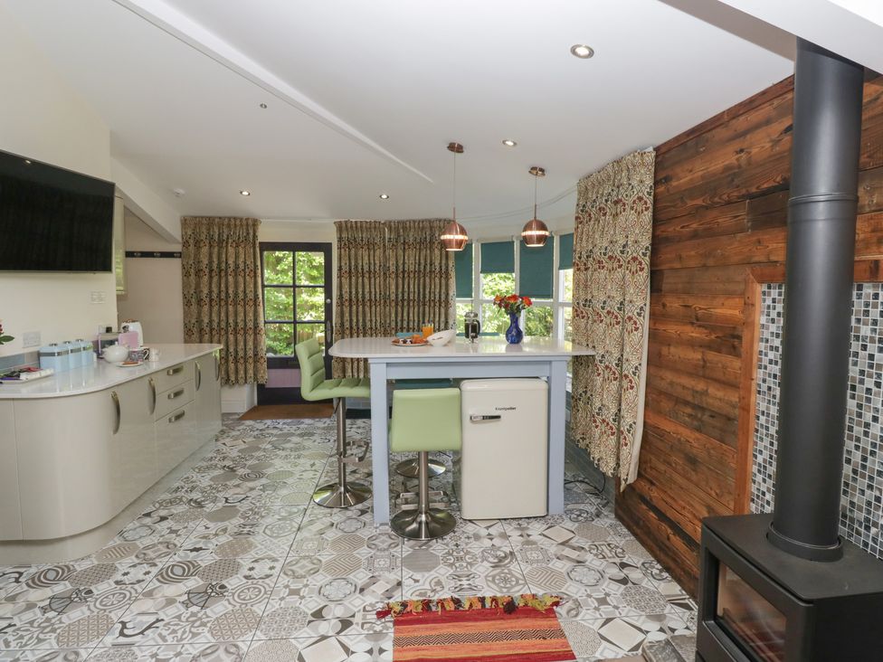 A kitchen with a countertop and refrigerator at Lilac Cottage in Grange-Over-Sands