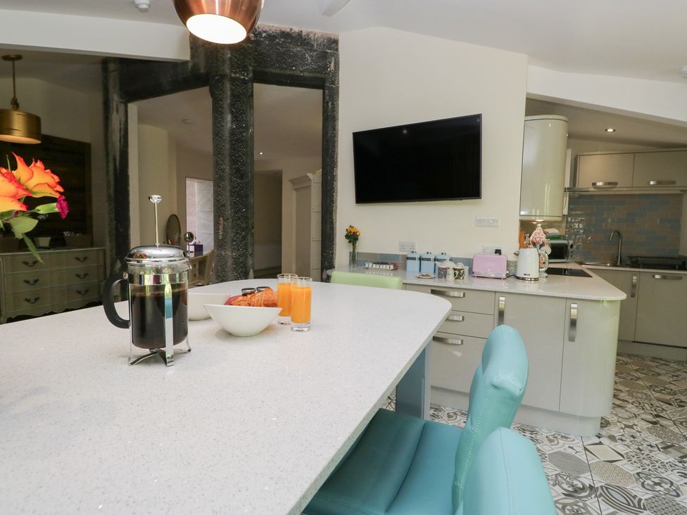 A kitchen with a coffee maker and bowls on a table at Lilac Cottage in Grange-Over-Sands