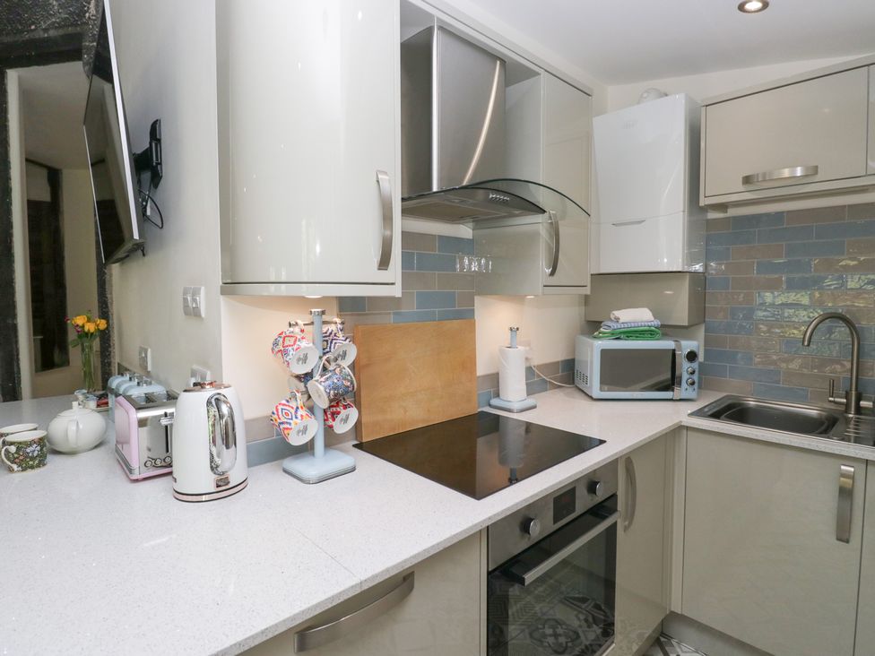 A kitchen with a sink and appliances at Lilac Cottage in Grange-Over-Sands