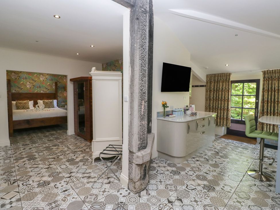 A bedroom with a bed and wardrobe at Lilac Cottage Grange-Over-Sands