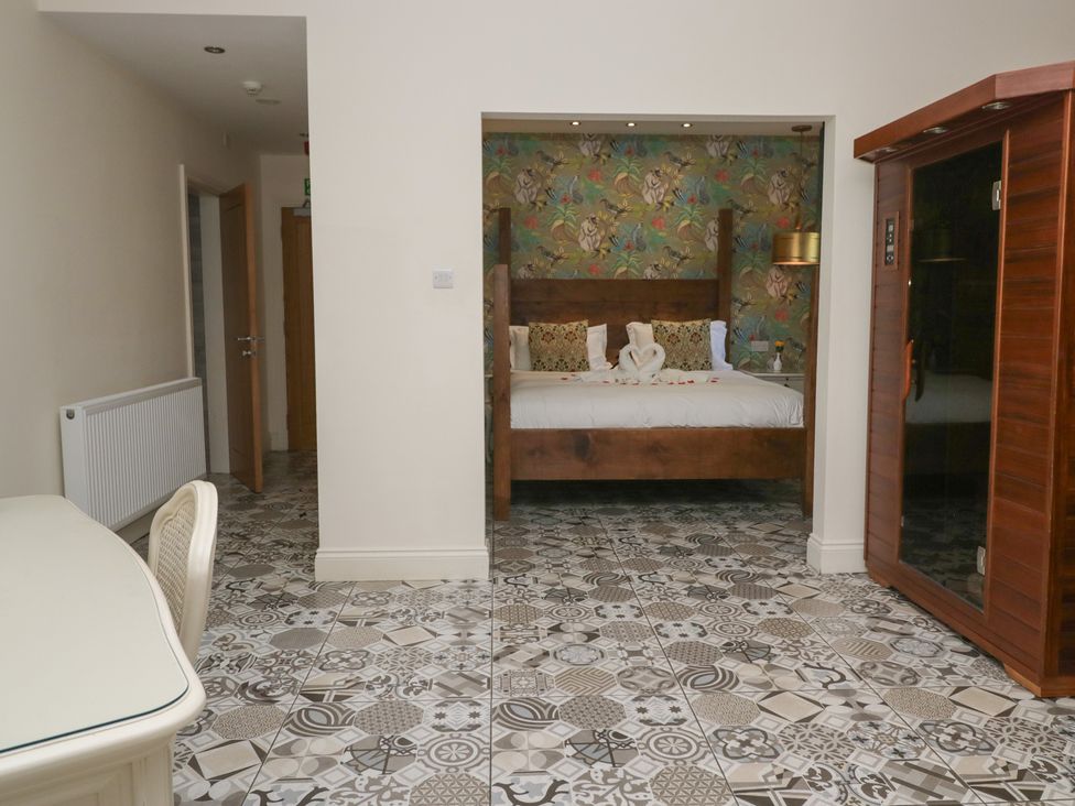 A bedroom with a bed and a table at Lilac Cottage in Grange-Over-Sands