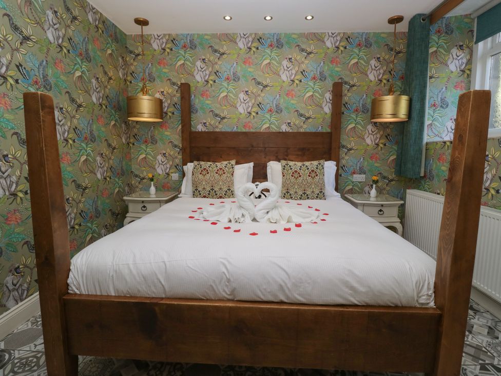A bedroom with a bed and decorative items at Lilac Cottage in Grange-Over-Sands