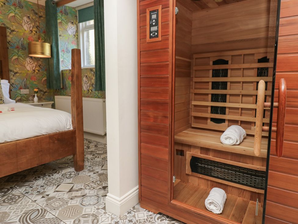 A bedroom featuring a bed and a sauna at Lilac Cottage in Grange-Over-Sands