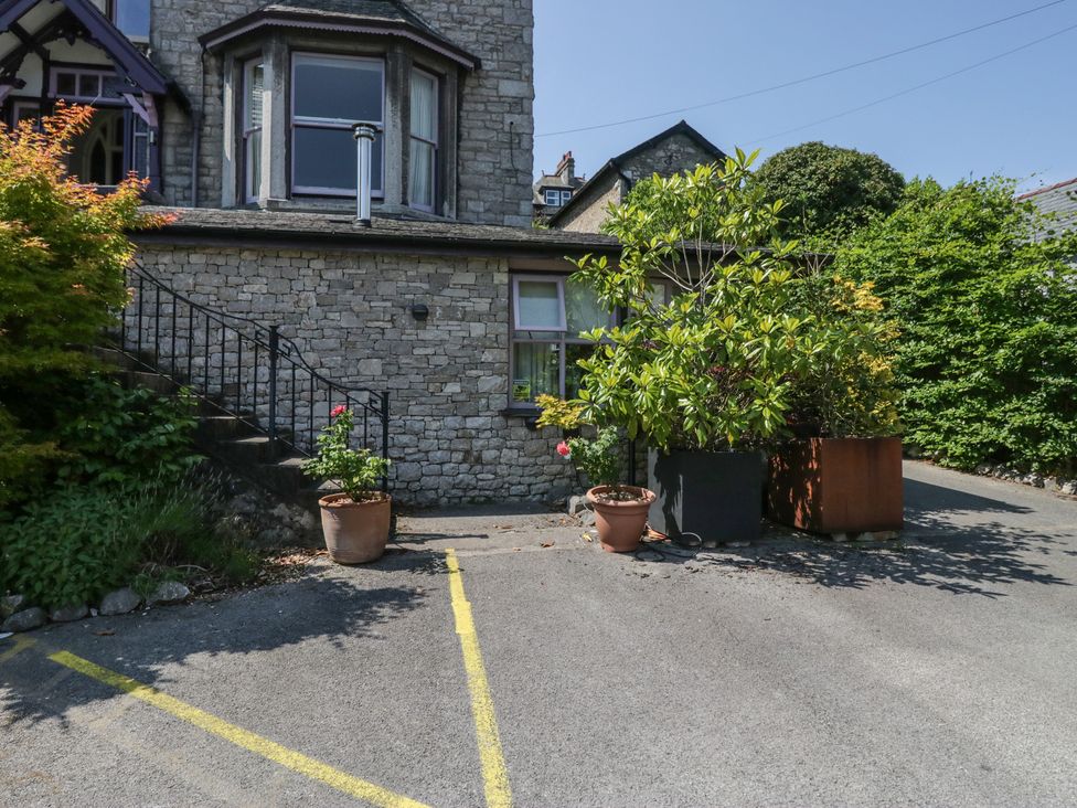 An outdoor area with a house, garden planters and a driveway at Lilac Cottage in Grange-Over-Sands