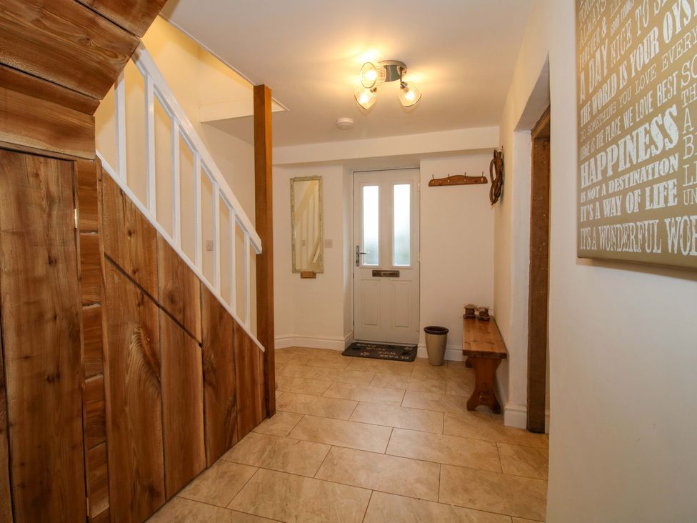 An entrance hall with stairs and a door at 1 Dingle Cottage in Worcester