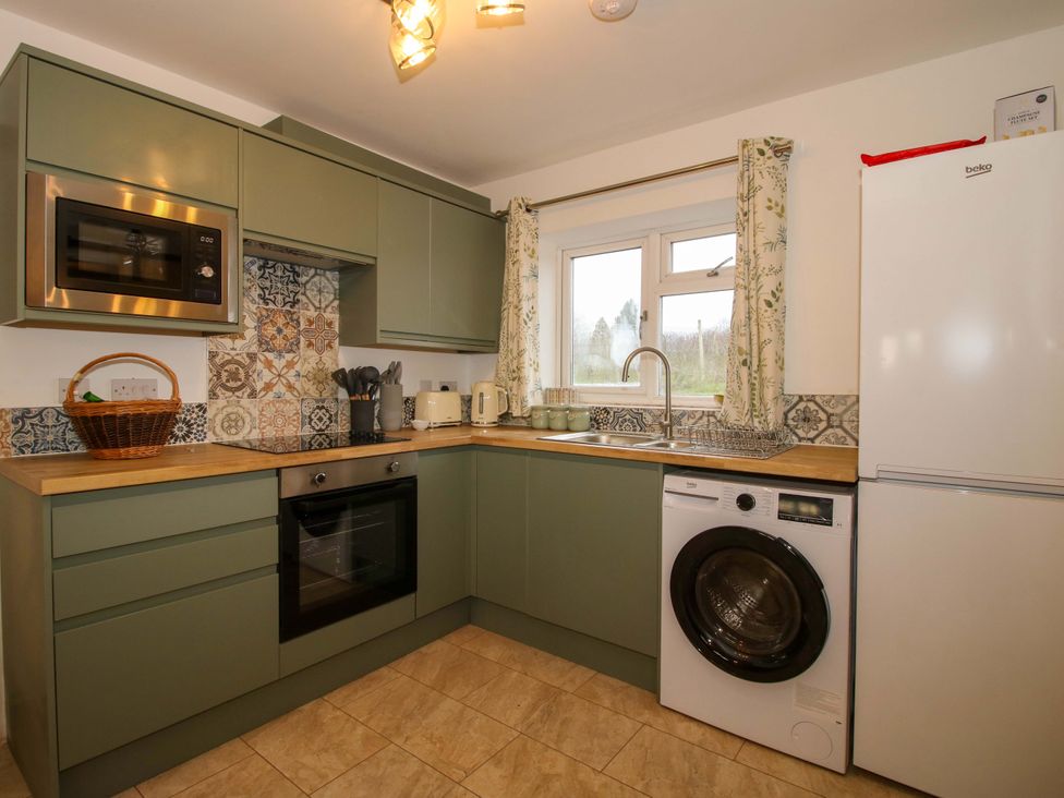 A kitchen with appliances and a window at 1 Dingle Cottage in Worcester