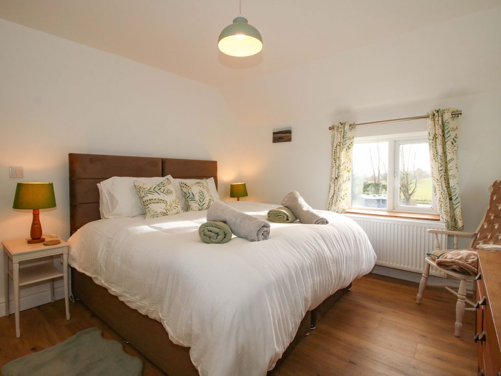 A bedroom with a double bed and bedside tables at 1 Dingle Cottage in Worcester