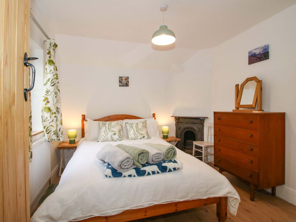 A bedroom with a double bed and furniture at 1 Dingle Cottage in Worcester