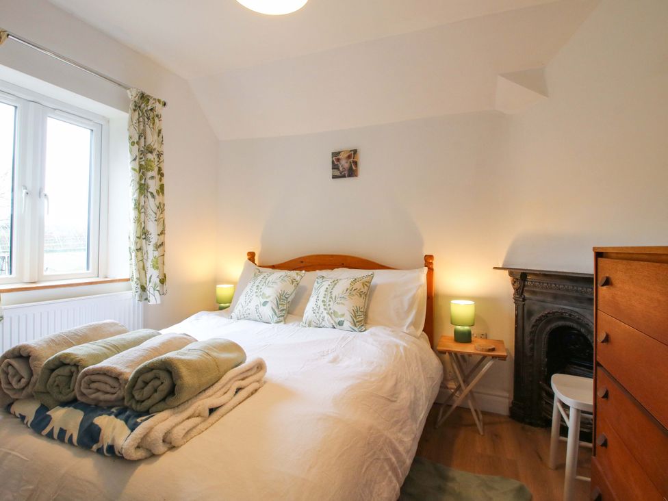 A bedroom with a bed and furniture at 1 Dingle Cottage Worcester