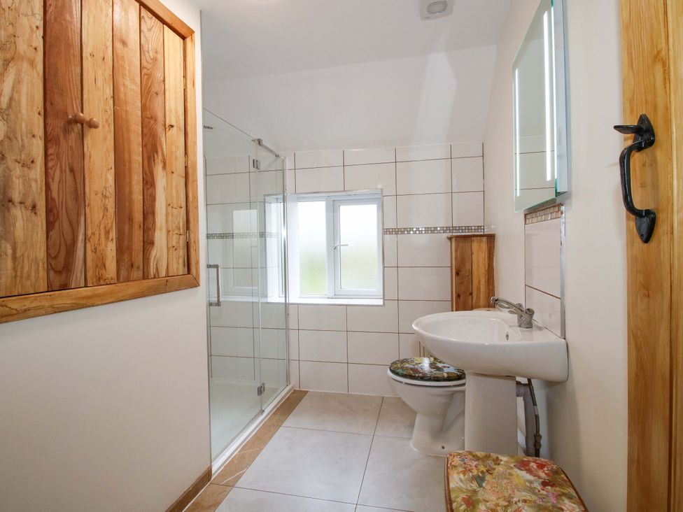 A bathroom with a shower, sink, and toilet at 1 Dingle Cottage in Worcester
