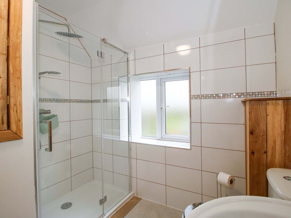 A bathroom with a shower and toilet at 1 Dingle Cottage in Worcester