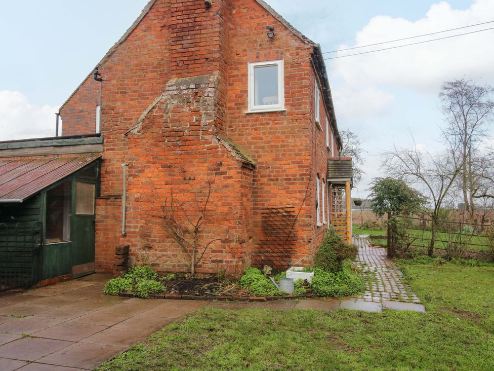 A brick building with a pathway and garden at 1 Dingle Cottage Worcester