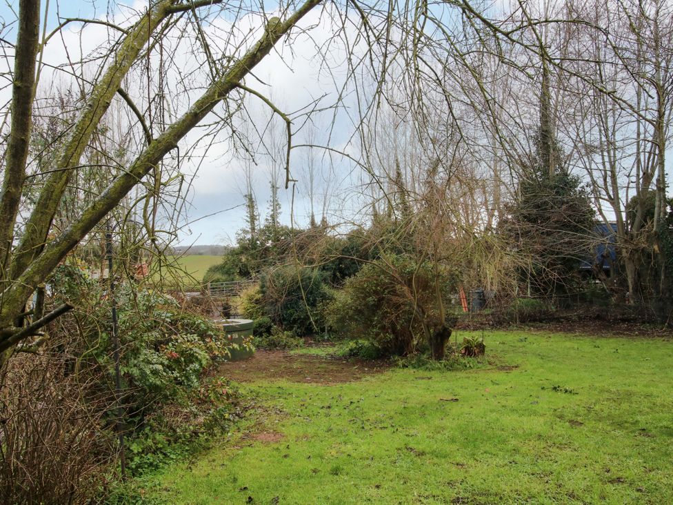 A garden with trees and grass at 1 Dingle Cottage Worcester