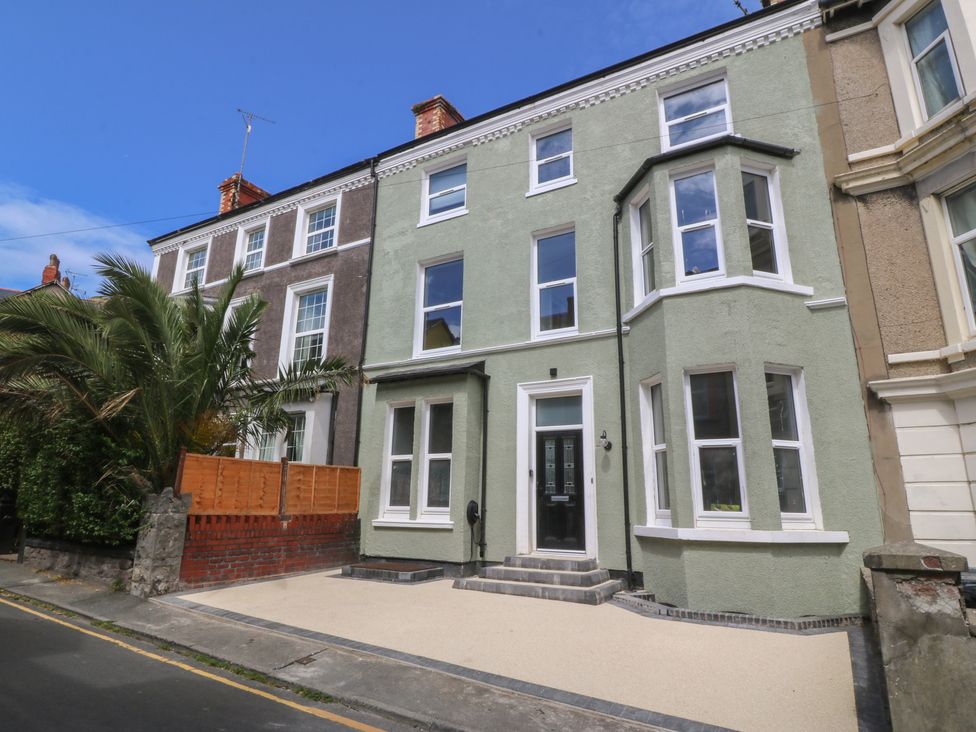 An exterior view of a house with palm tree and driveway at Fox House in Llandudno