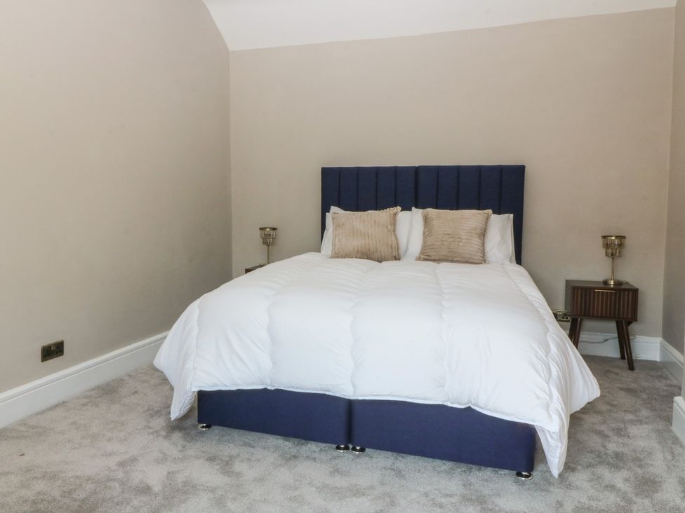 A bedroom with a bed and side table at Fox House in Llandudno
