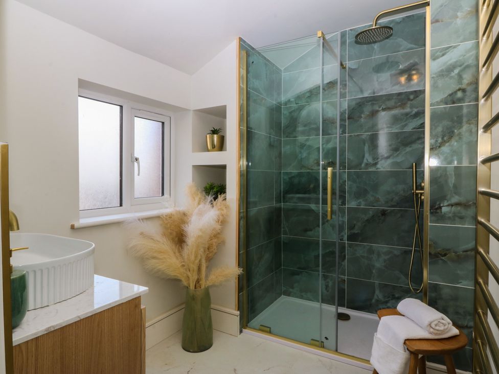 A bathroom with a shower, sink, and towel at Fox House in Llandudno