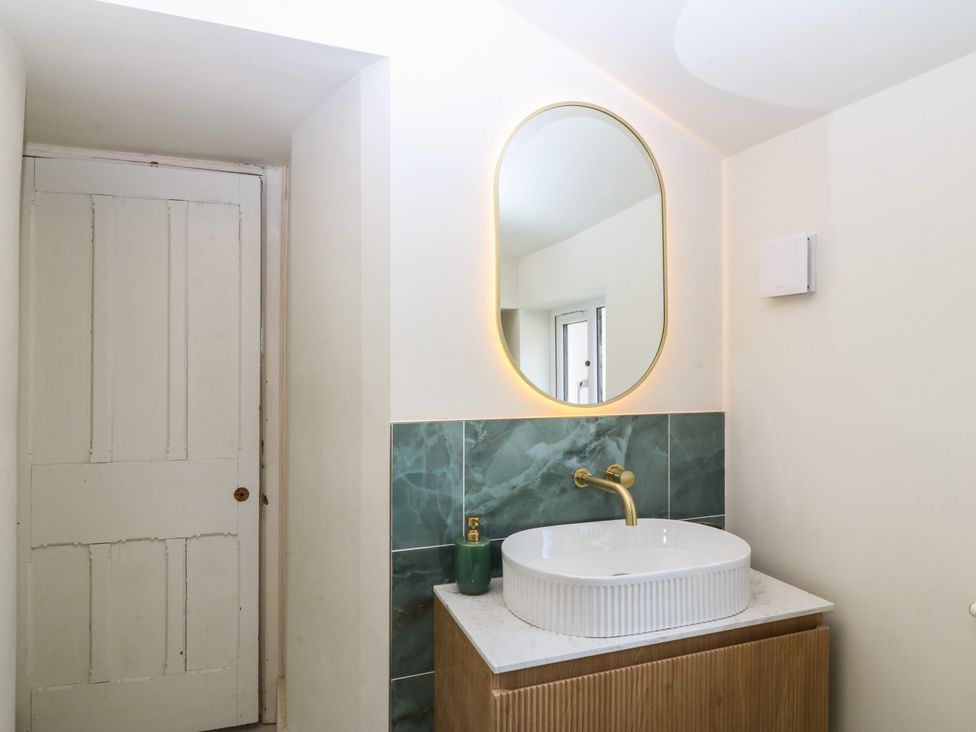 A bathroom with a sink and mirror at Fox House in Llandudno