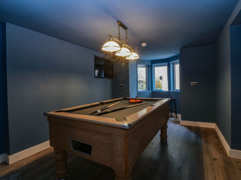 A games room with a pool table and windows at Fox House in Llandudno