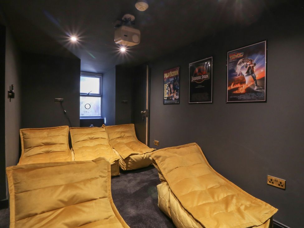 A cinema room with seating and a projector at Fox House in Llandudno