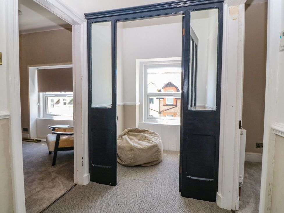 A hallway with a doorway and windows at Fox House in Llandudno