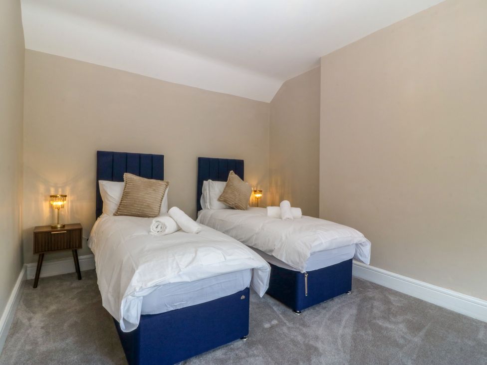 A bedroom with two single beds at Fox House in Llandudno