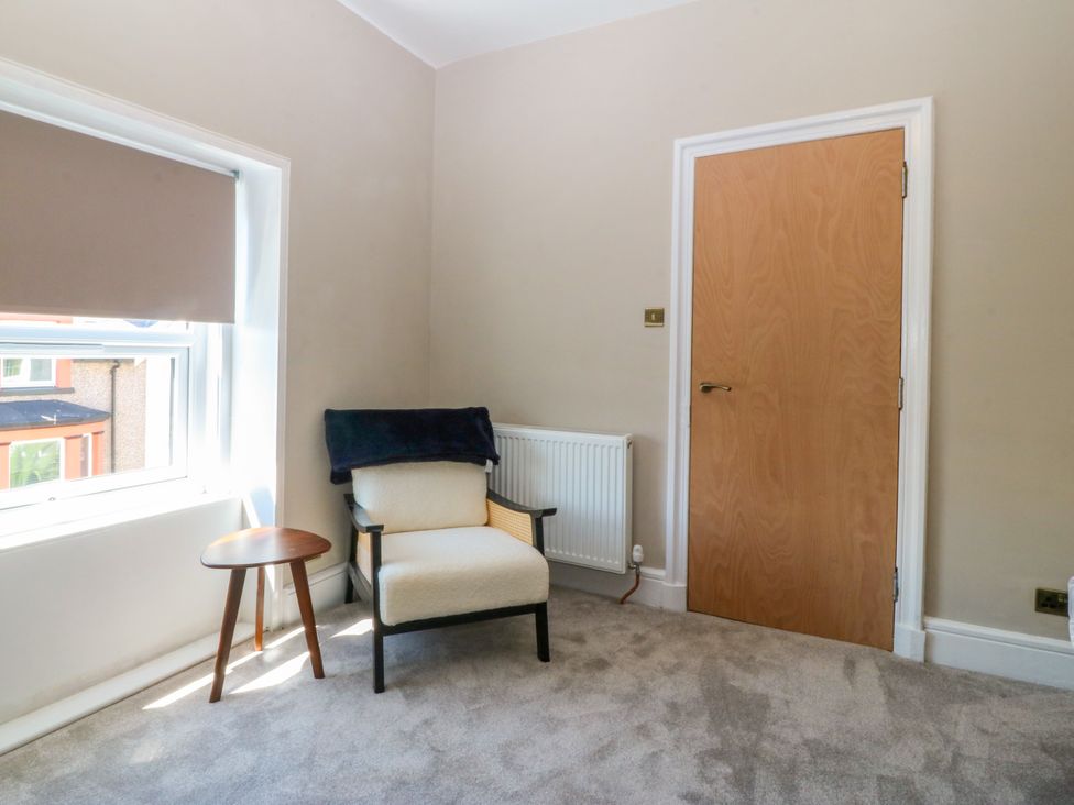 A room with a chair and side table at Fox House in Llandudno