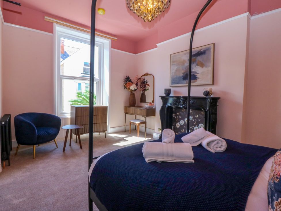 A bedroom with a bed and chair at Fox House in Llandudno
