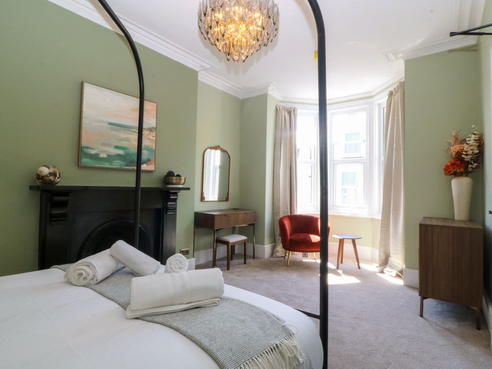 A bedroom with a bed and a chair at Fox House in Llandudno