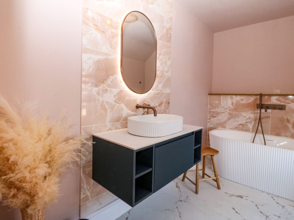 A bathroom with a sink and bathtub at Fox House in Llandudno