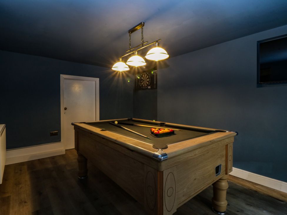 A game room with a pool table and dart board at Fox House in Llandudno