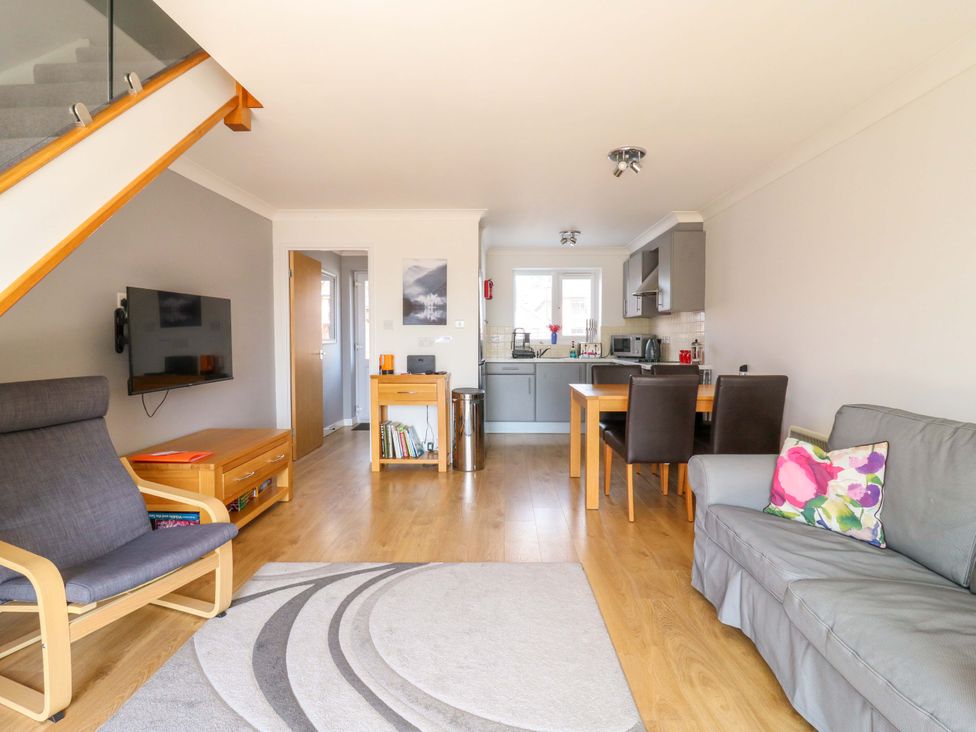 A living room with a sofa and dining area at Kingsmere Norwich