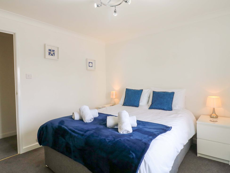 A bedroom with a bed and nightstands at Kingsmere in Norwich