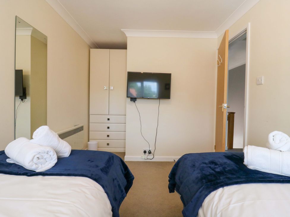 A bedroom with two beds and a television at Kingsmere Norwich