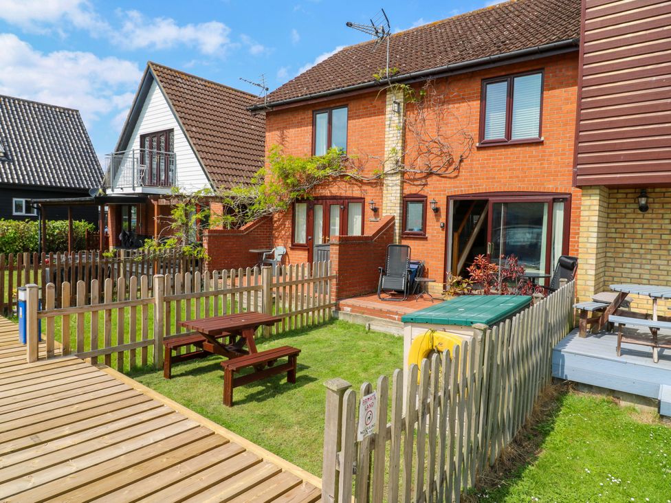 A garden with a table and bench in front of a house at Kingsmere Norwich