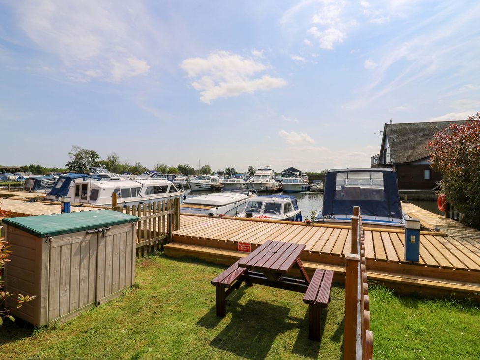 An outdoor area with boats at a dock and a shed at Kingsmere in Norwich