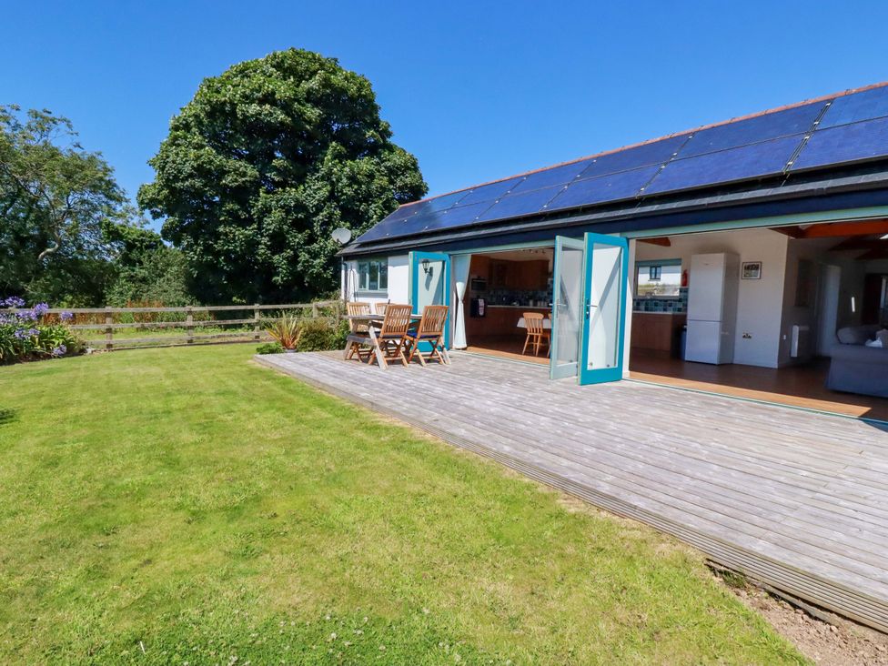 An outdoor area with wooden deck and table with chairs at Little Chywoon Barn Truro