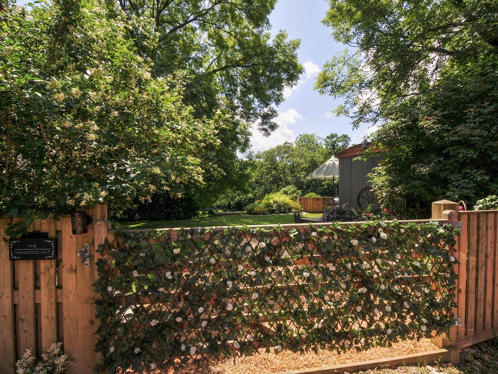 A garden with a wooden gate and fence at The Highwood Hut near Liskeard