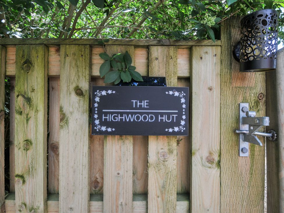 A sign that says THE HIGHWOOD HUT on a wooden gate near Liskeard