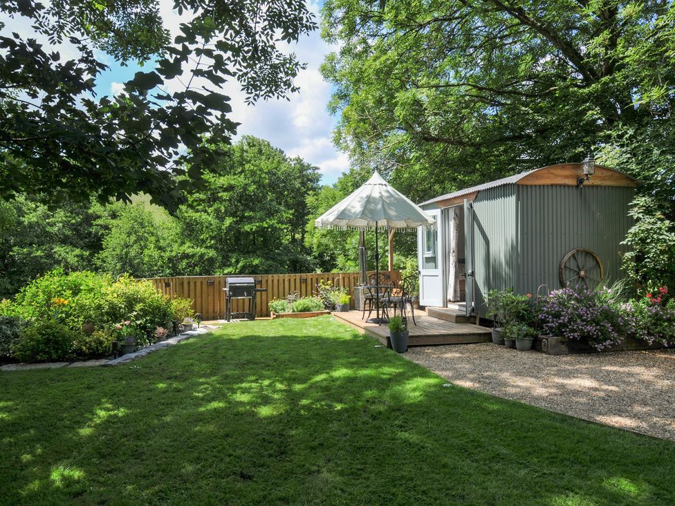 A garden with a shed and seating area at The Highwood Hut near Liskeard
