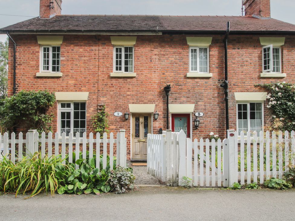 A house with a white fence and plants at 2 Aqueduct Cottages Chirk Bank near Chirk